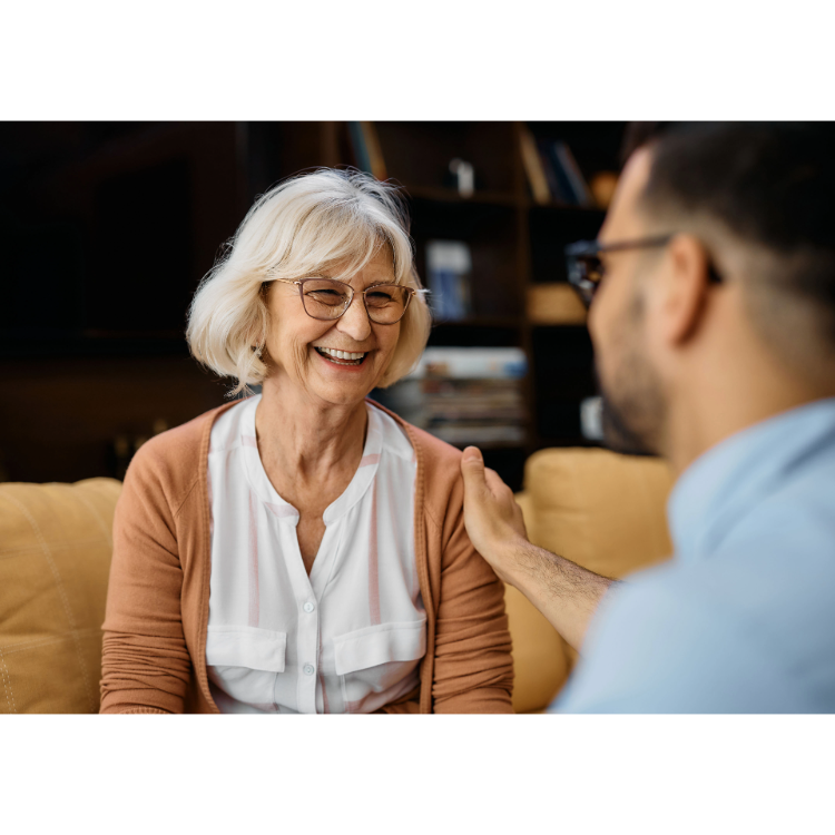 Older adult smiling at home with a trusted carer nearby
